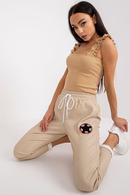 Close-up of Luxury Women's Ecological Leather Trousers With Elastic Waistband - Italy Moda, highlighting the elegant design and unique patch detail, styled with a beige top.