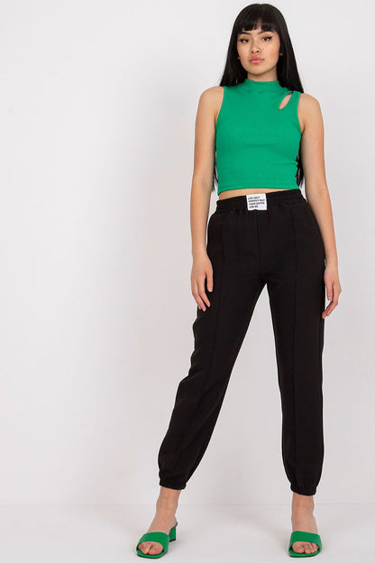 Trendy woman in Women’s Luxury High-Rise Trousers with Elastic Waist and Pockets by Italy Moda, styled with a green crop top and black heels, exuding elegance.