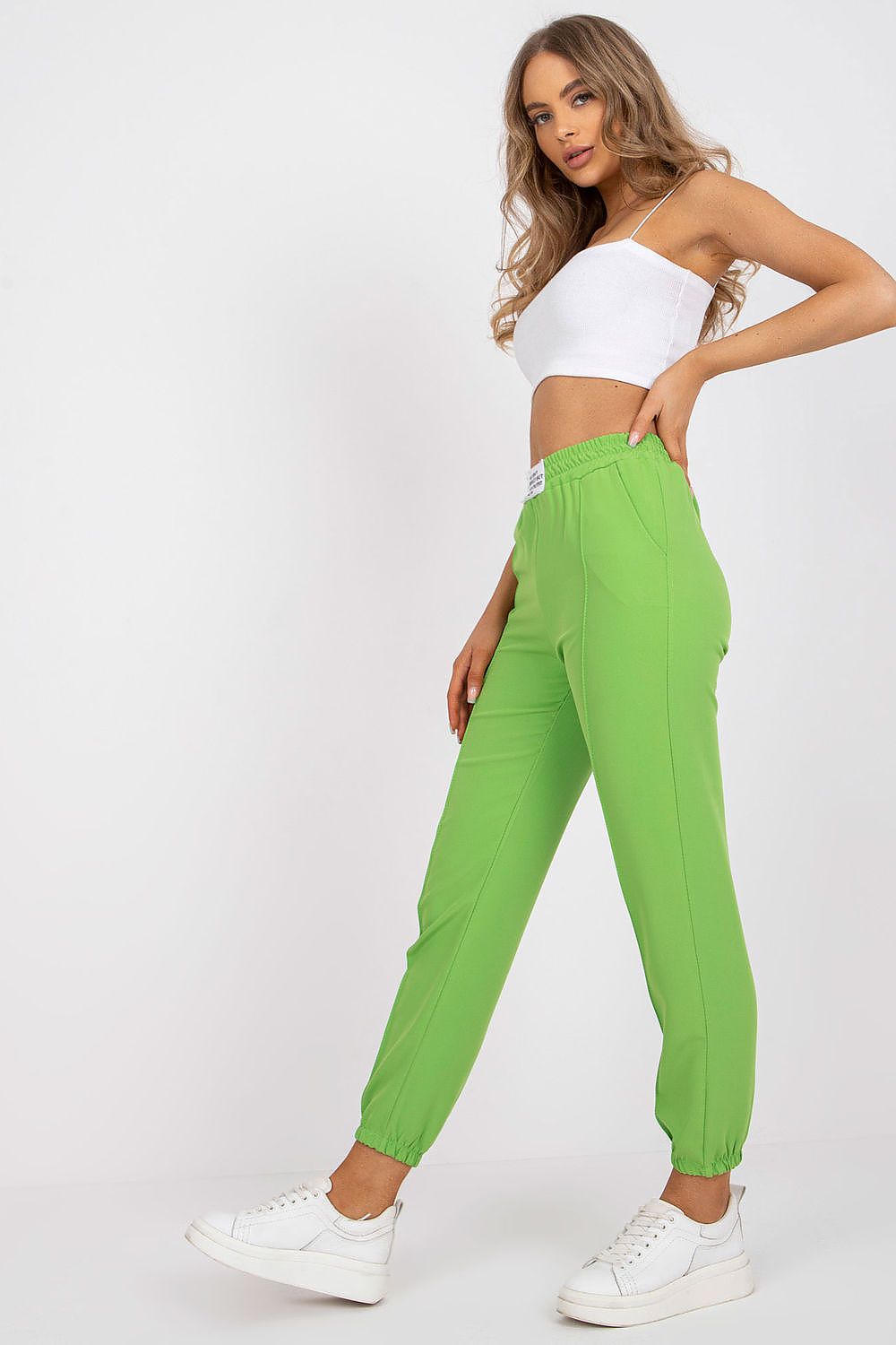 Luxurious women's high-rise trousers in vibrant green from Italy Moda, featuring an elastic waist and paired with a chic white crop top.
