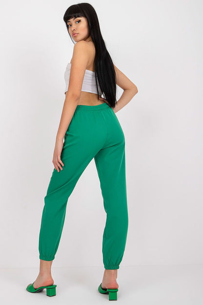 Fashion-forward women's high-rise trousers in striking green by Italy Moda, featuring an elastic waistband, styled with a contemporary white crop top.