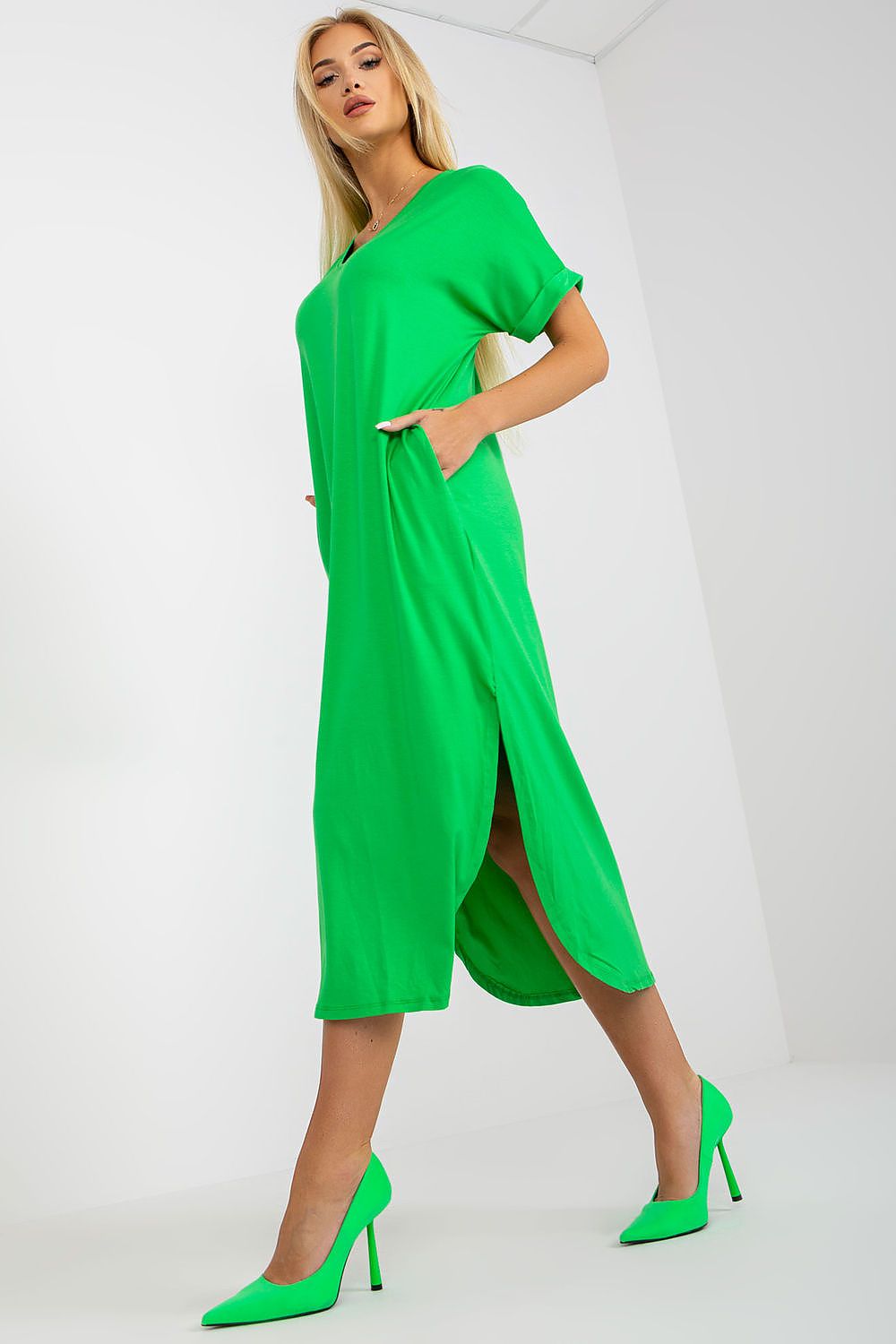 Sophisticated luxury short-sleeved daydress by Och Bella in bold green, featuring side pockets and flattering slits for a modern look.