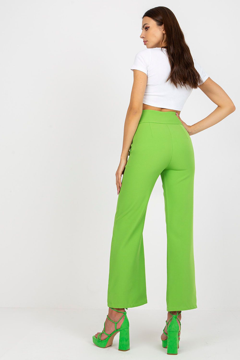 Fashion-forward green high-waisted trousers with decorative buttons from Italy Moda, highlighted on a model demonstrating a sophisticated look.
