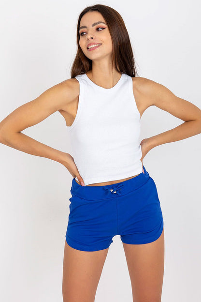 BFG Classic Ribbed T-Shirt - Black, model smiling in a white version of the ribbed top, paired with vibrant blue shorts, radiating luxury and style.