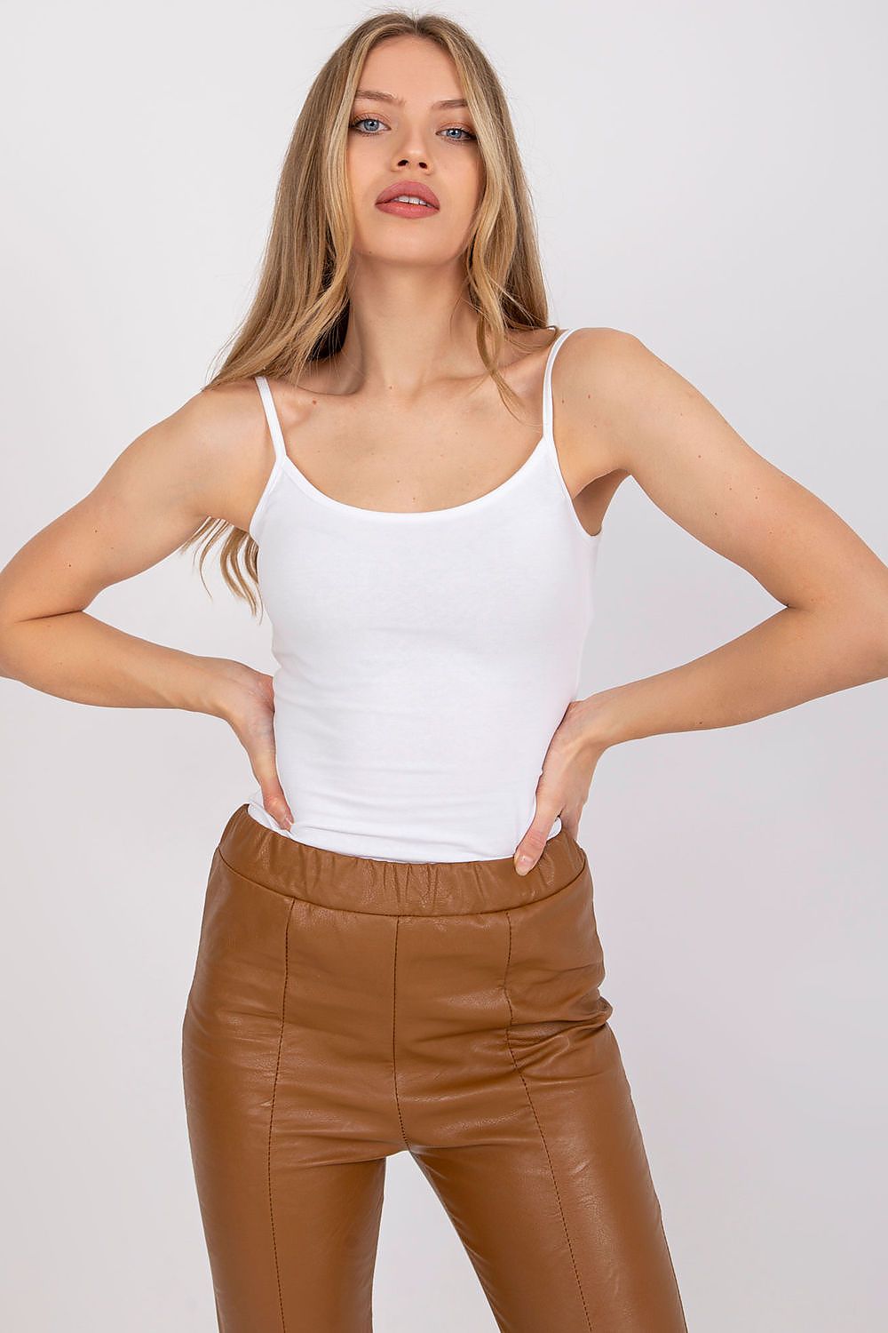 Luxurious Cotton Spandex Strapless Shirt with Round Neckline - Model poses in a classic white strapless shirt paired with fashionable brown leather pants, showcasing luxury and adaptability.