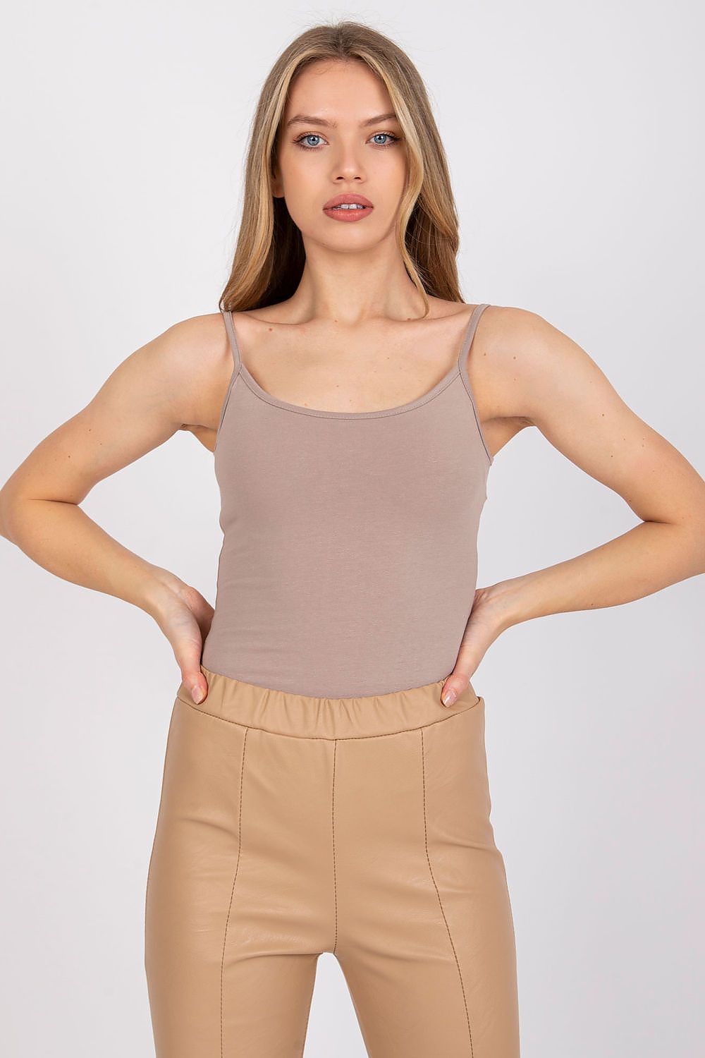 Model in a luxurious cotton spandex strapless shirt with round neckline in a chic taupe colour, styled with beige leather trousers - perfect for versatile styles.