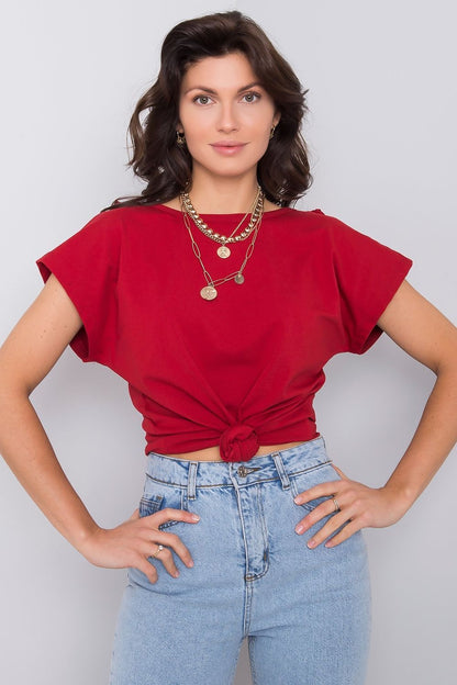 Chic red variation of the elegant short sleeve blouse with frill trimmed deep cut-out, model styled with gold accessories, showcasing the trendy knot front detail.