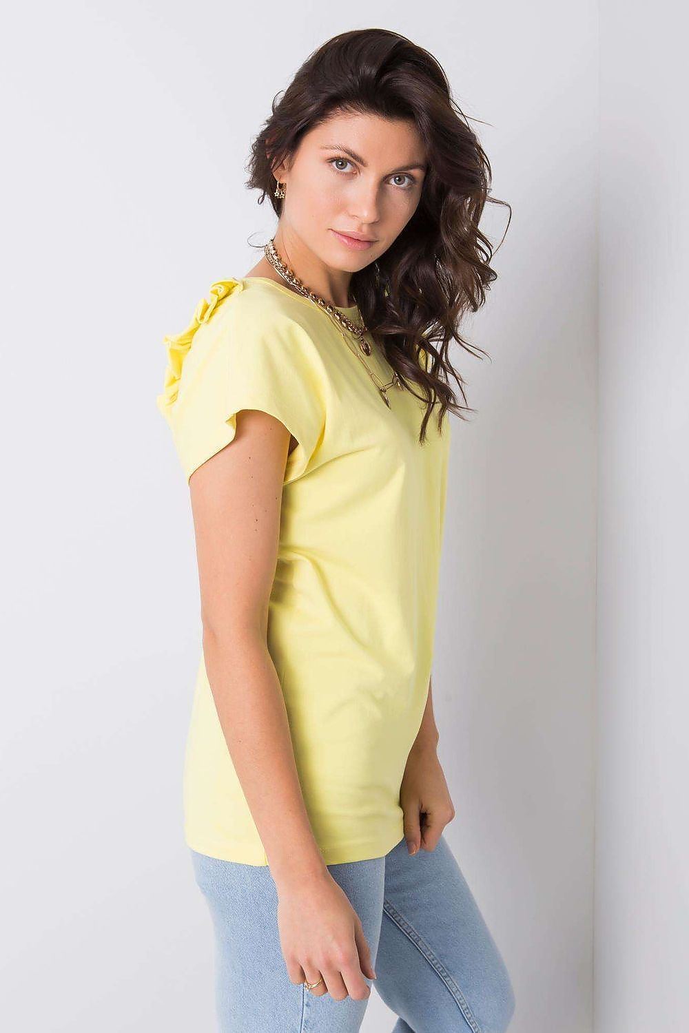 Side view of the Elegant Short Sleeve Blouse With Frill Trimmed Deep Cut-Out in a vibrant yellow, highlighting the stylish shoulder design worn by a model.