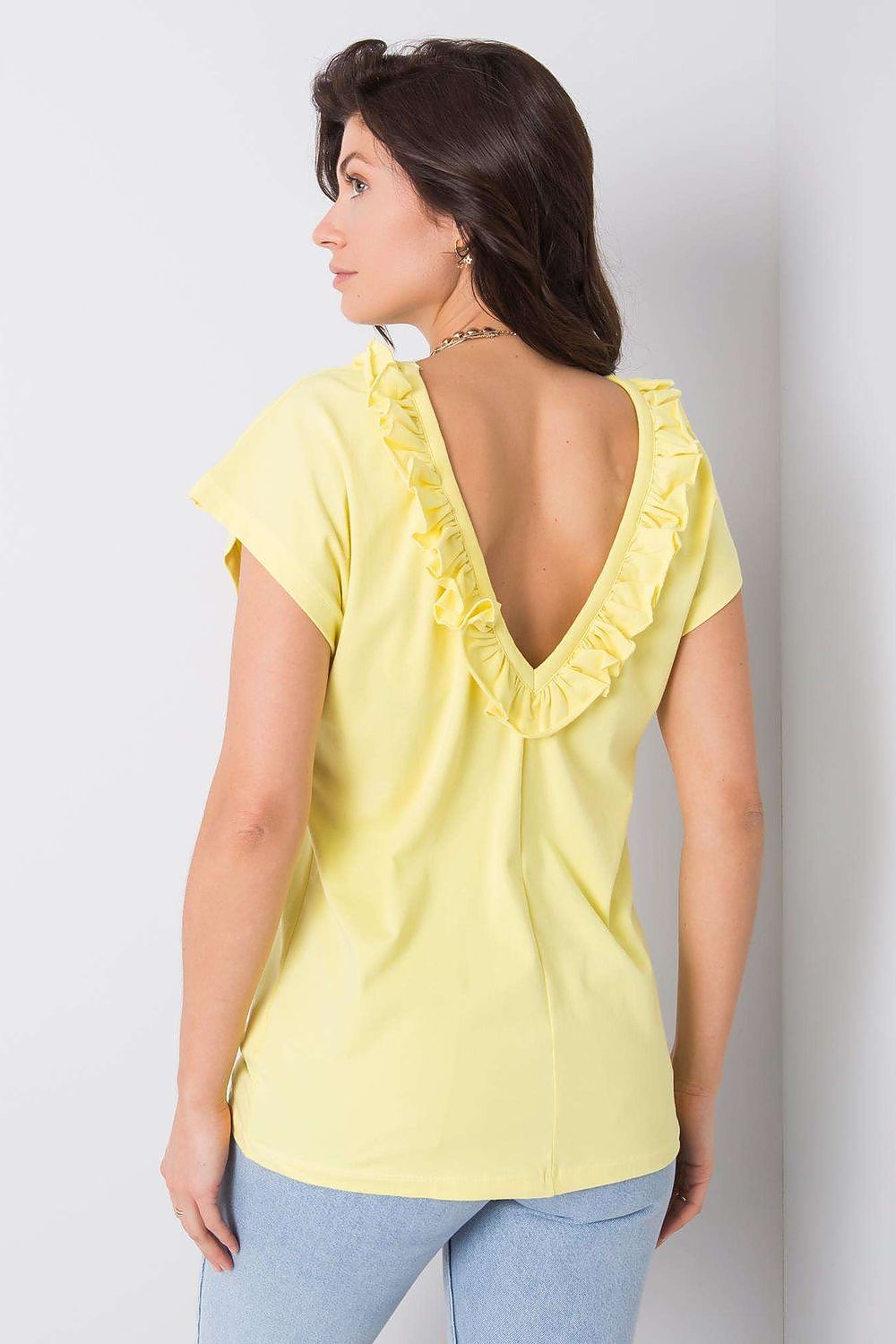 Back view of the Elegant Short Sleeve Blouse With Frill Trimmed Deep Cut-Out in yellow, emphasizing the delicate frill trim and deep cut-out, styled by a woman.