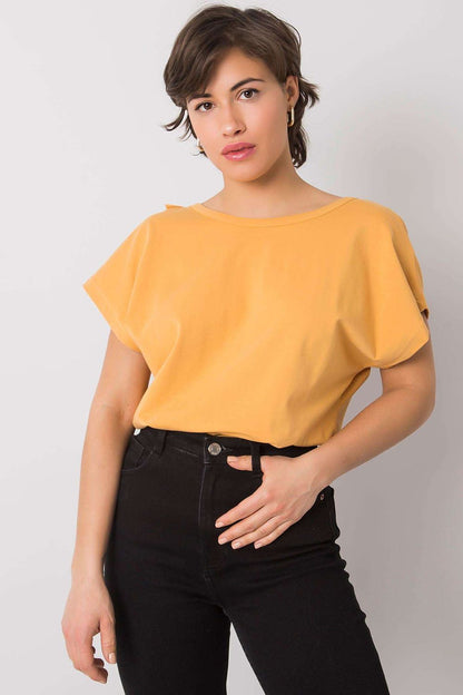 Model presenting the Elegant Short Sleeve Blouse With Frill Trimmed Deep Cut-Out in warm yellow, paired with high-waisted black jeans, exuding modern elegance.