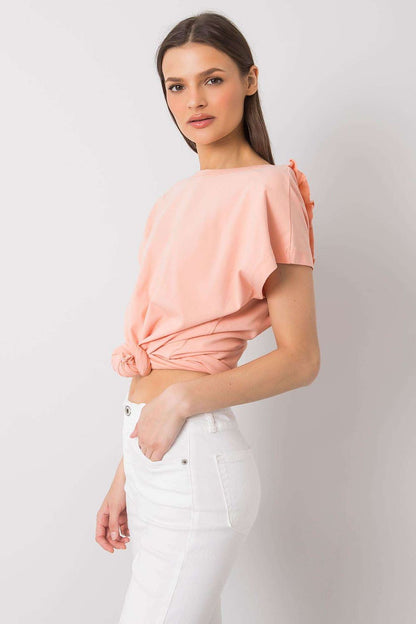 Elegant short sleeve blouse with frill trimmed deep cut-out in a soft peach hue, featuring a fashionable side knotted design for a contemporary style.