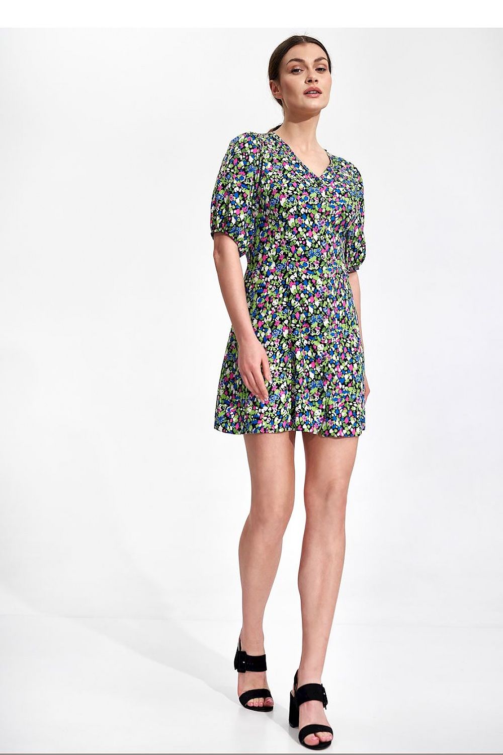 Side view of an elegant summer mini dress by Figl, showcasing its stunning floral design, short loose sleeves and feminine shape.