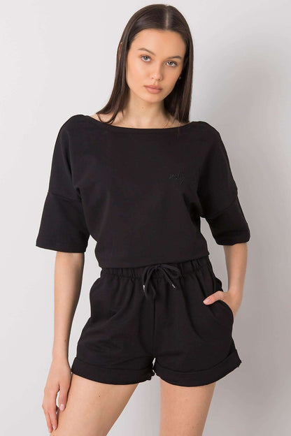 Elegant Cotton Blouse And Shorts Set With Elastic Waistband And Slip-On Pockets. A stylish model showcases a black loose-fit cotton blouse and matching shorts, featuring an elastic waistband and convenient side pockets, perfect for a chic summer look.