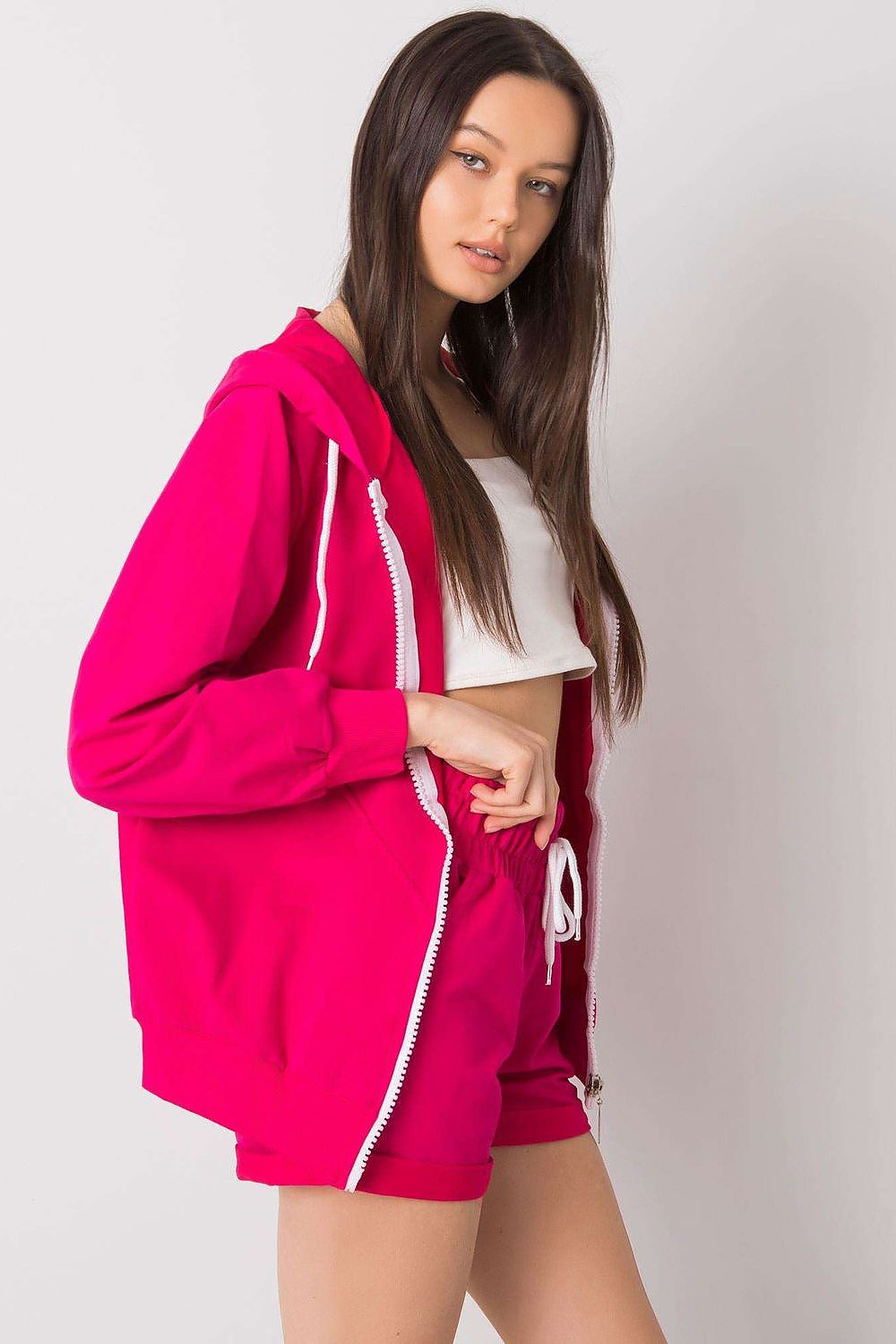 Luxury Tracksuit Set in striking pink, model exuding confidence while wearing a zippered hoodie and comfortable elastic waist shorts, perfect for a chic casual ensemble.