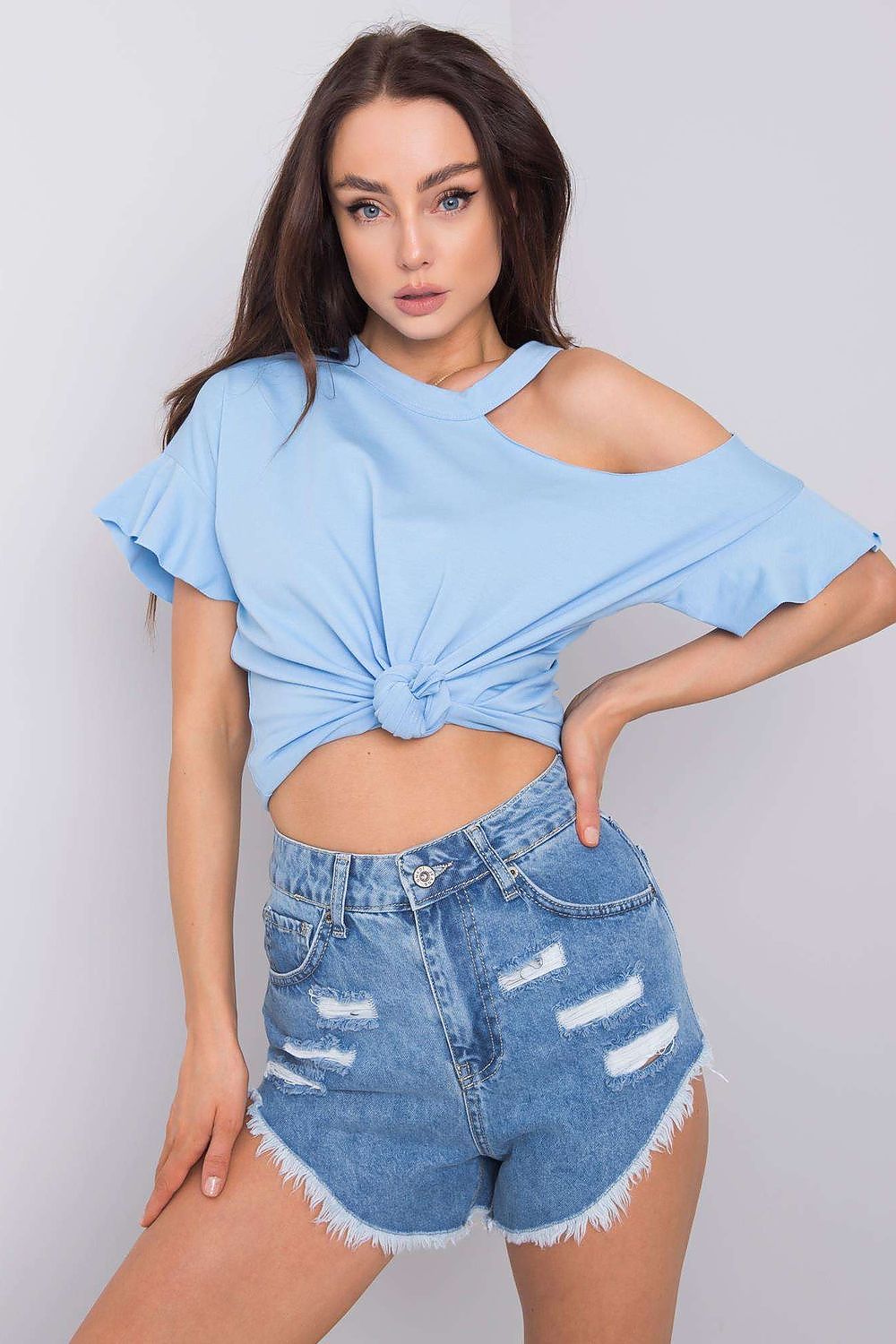Elegant model wearing a stylish off-shoulder cotton blend blouse with short sleeves in blue, paired with distressed denim shorts, showcasing a chic, trendy look.