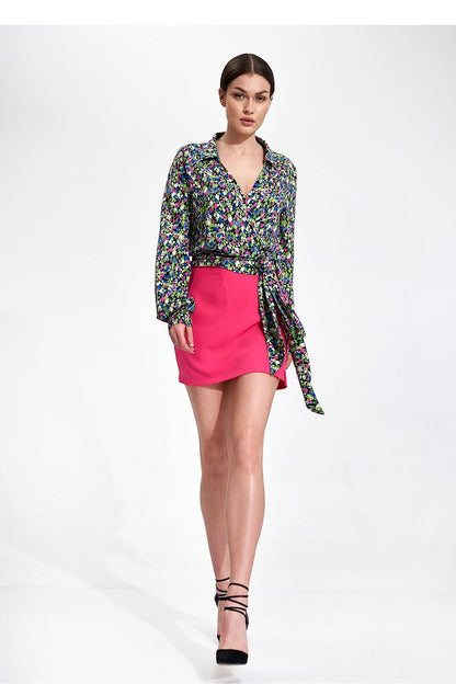 Elegant Envelope Blouse With Pleated Sleeves And Sash - Figl Fashion, featuring a model striking a confident pose in a floral blouse and pink skirt, accentuating the luxurious pleated sleeve design and waist sash.