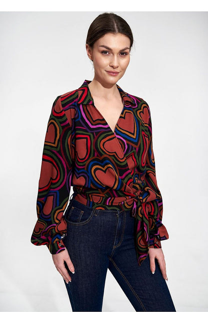 Elegant Envelope Blouse With Pleated Sleeves And Sash - Figl Fashion, showcasing a model in a vivid patterned wrap blouse with heart designs, elegantly styled with jeans for a chic and luxurious appearance.