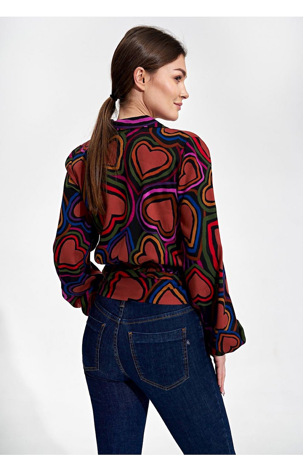 Elegant Envelope Blouse With Pleated Sleeves And Sash - Figl Fashion, featuring a model from a rear angle, highlighting the beautiful design and luxurious fabric of the blouse, elegantly styled with fitted jeans.