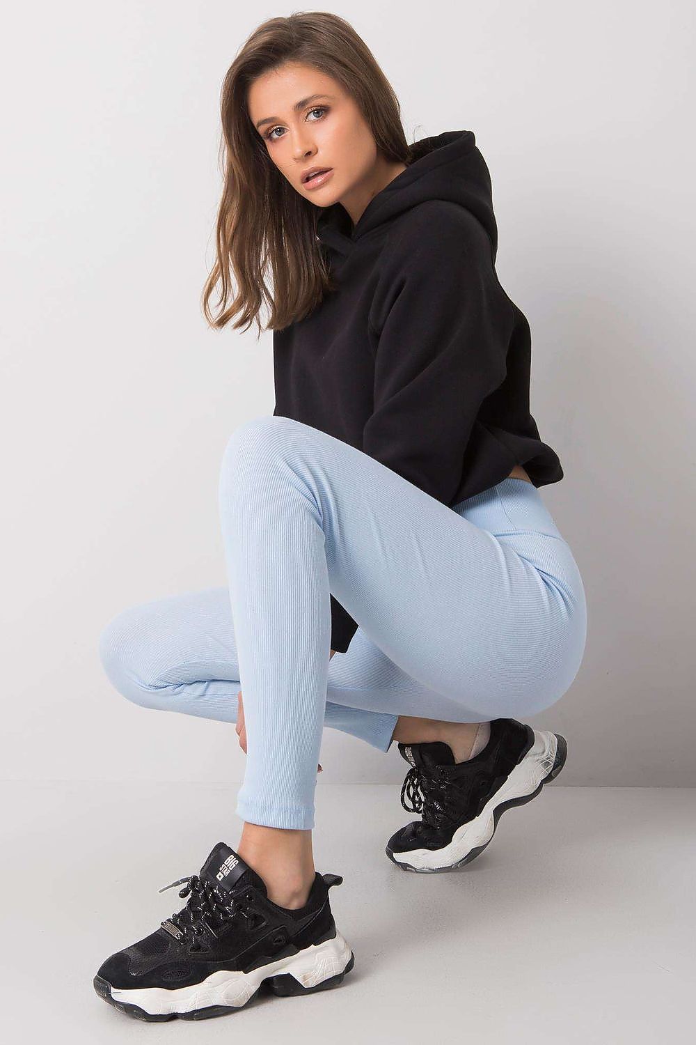 Elegant High-Waisted Ribbed Leggings for Women by BFG, showcasing a model in light blue leggings paired with a black oversized hoodie and stylish sneakers, exuding a chic yet relaxed vibe.