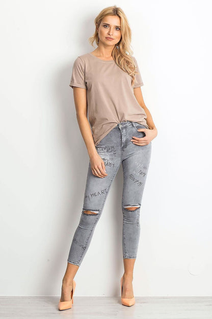 Charming front view of a model in the Luxurious Ladies Cotton Spandex Short-Sleeved T-Shirt with Round Neckline, perfectly styled with fashionable ripped jeans.