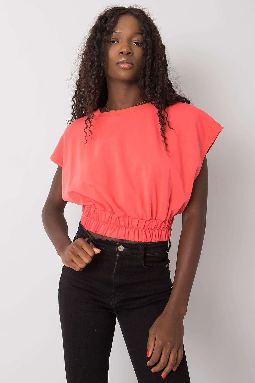 Luxury Ladies' Loose Fit Sweatshirt with Short Sleeves and Wide Rubber Band in coral colour, styled elegantly with black high-waisted jeans, showcasing relaxed fashion appeal.