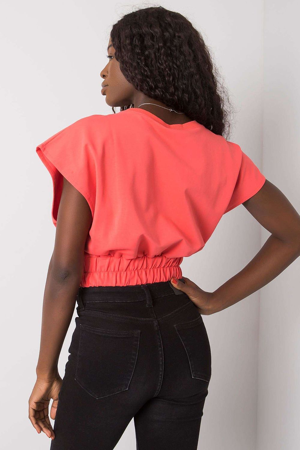 Luxury Ladies' Loose Fit Sweatshirt with Short Sleeves and Wide Rubber Band shown in vibrant coral, expertly styled with black denim for a chic and effortless look.