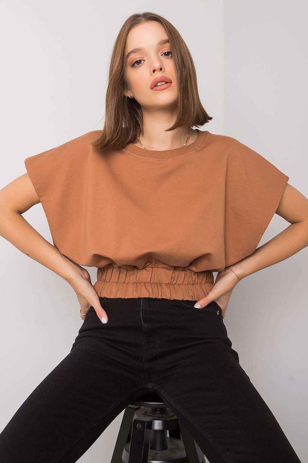 Luxury Ladies' Loose Fit Sweatshirt with Short Sleeves and Wide Rubber Band displayed in a rich brown hue, elegantly paired with black jeans and a relaxed posture.