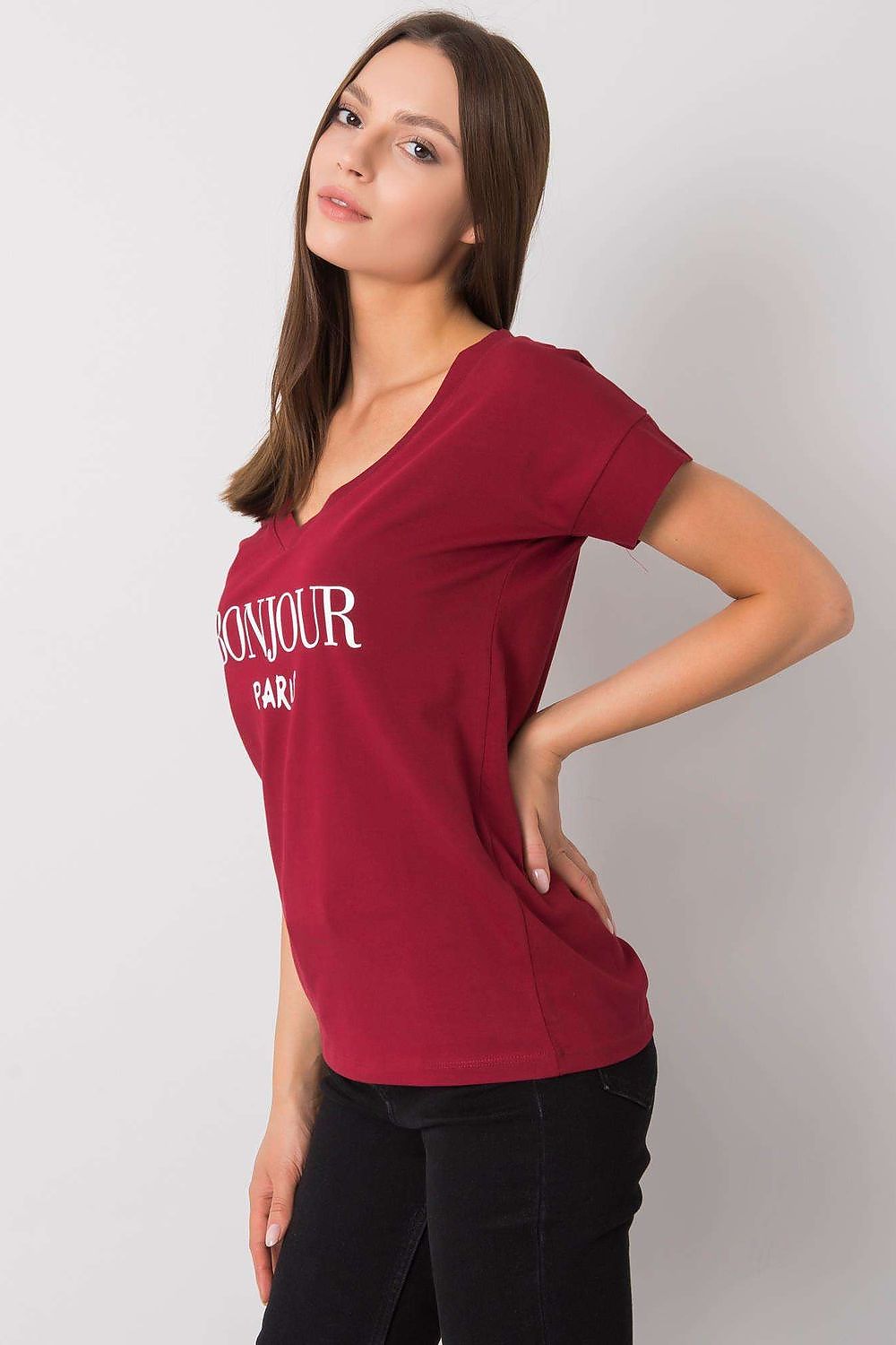 Elegant Women's V-Neck T-Shirt in Soft Cotton-Lycra Blend with Decorative Front Wording, model posing gracefully in a side view wearing a maroon shirt.