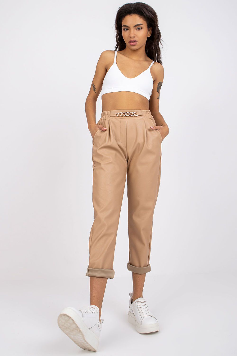 Luxury Women's 7/8 Eco Leather Trousers with High Rise and Decorative Chain by Italy Moda, model in beige eco leather trousers, exuding sophistication.