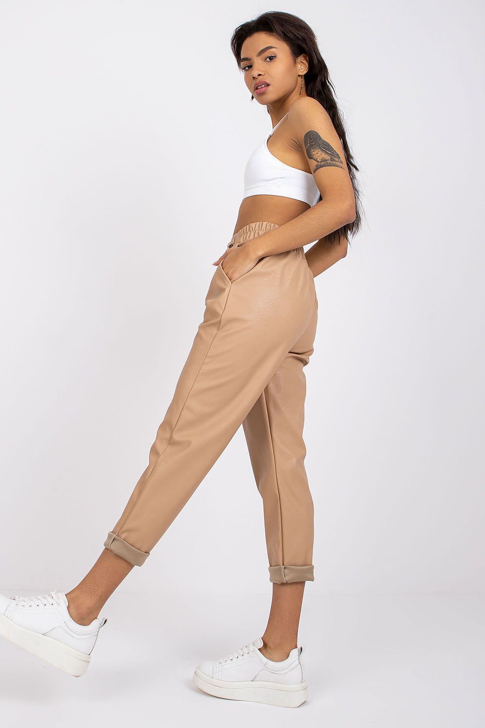 Luxury Women's 7/8 Eco Leather Trousers with High Rise and Decorative Chain by Italy Moda, styled with a white crop top and white sneakers, showcasing a trendy casual look.