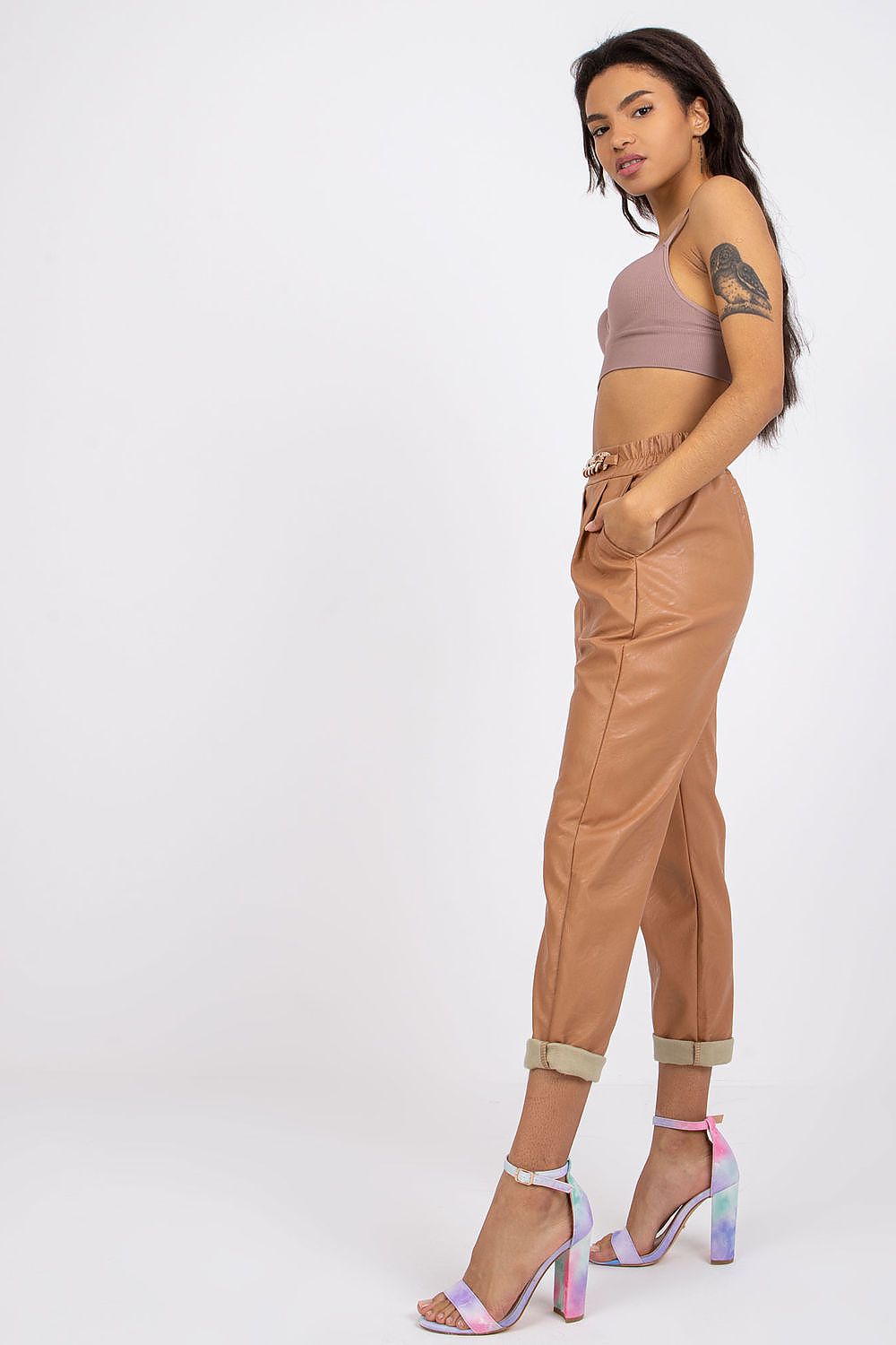 Luxury Women's 7/8 Eco Leather Trousers with High Rise and Decorative Chain by Italy Moda, paired with a brown crop top and colourful heels, exuding elegance and style.