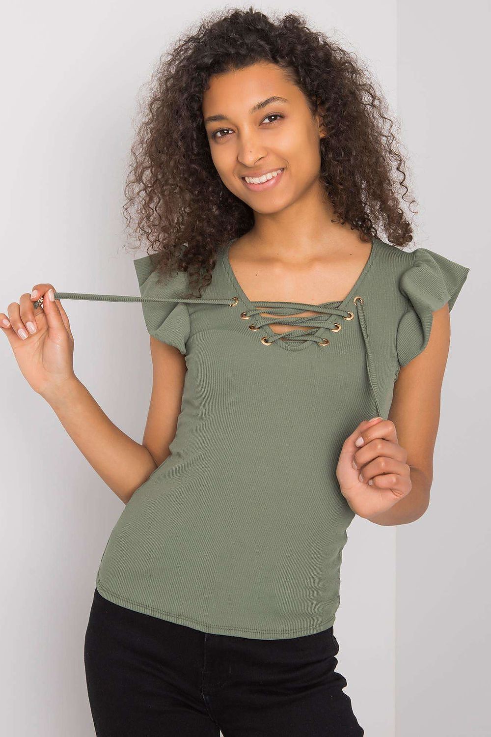 Charming model wearing the Luxurious Ribbed Frill Blouse with Decorative Cheese Neckline by Italy Moda in olive green, featuring playful frilly sleeves and lace-up detailing.