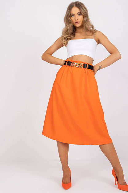 Elegant Italy Moda Skirt with Elastic Waistband, Side Pockets & Decorative Belt featuring a model in a striking orange colour, effortlessly styled with a white crop top and elegant orange heels.