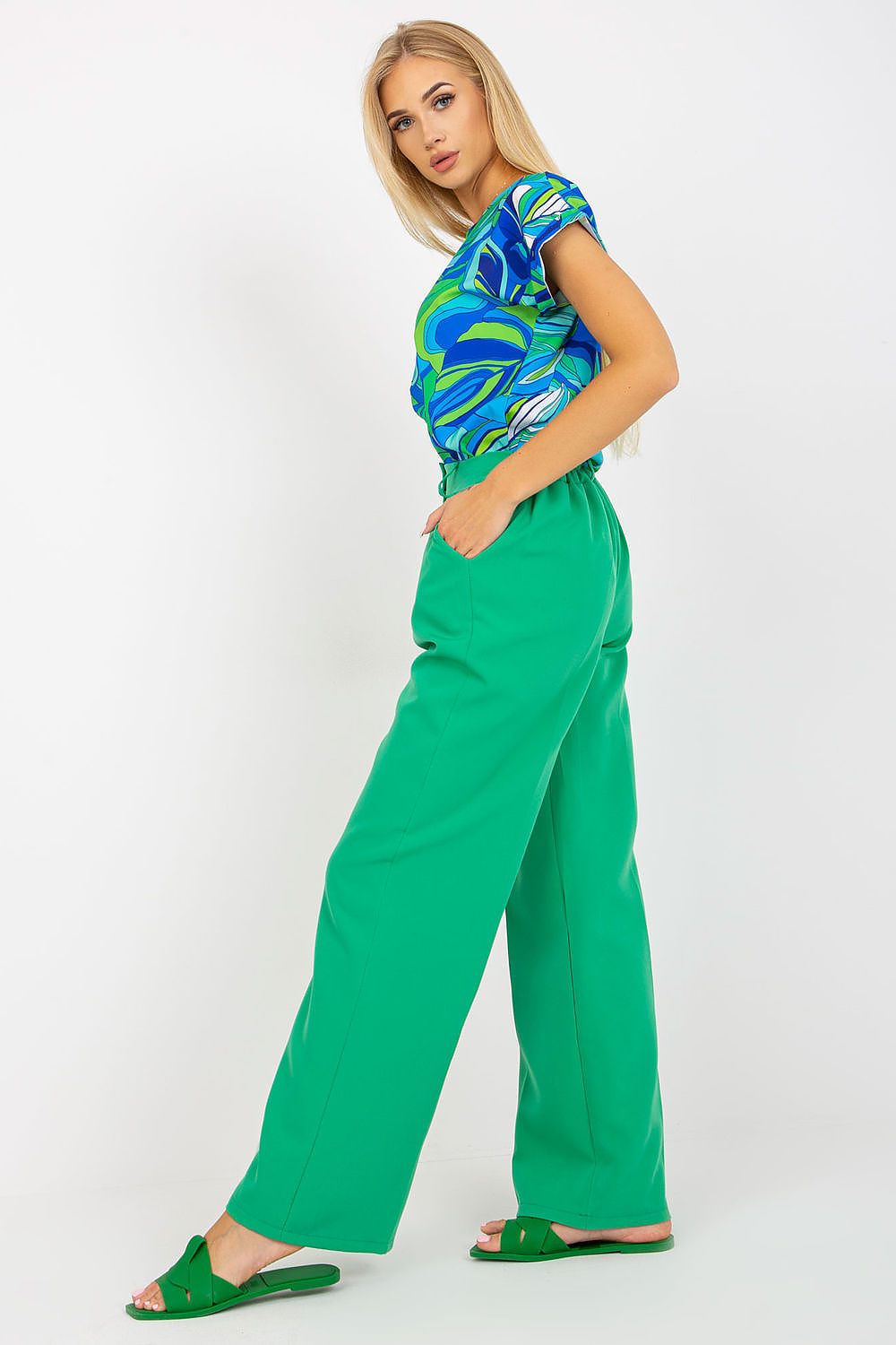 Luxury Women’s Italy Moda Trousers - High Rise Fabric Pants with Zip and Button Fastening, showcased in vibrant green, paired with a stylish blue patterned top, exemplifying elegance and modern fashion.