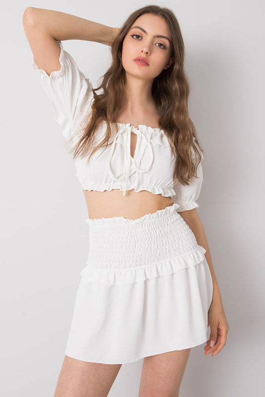 Och Bella Women's Short Summer Skirt with Wide Elastic Waistband showcased by a model wearing a matching cropped white top, epitomizing summer fashion elegance.