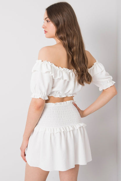 Back view of the Och Bella Women's Short Summer Skirt with Wide Elastic Waistband on a model wearing a white ruffled top, exemplifying comfort and trendiness for summer days.