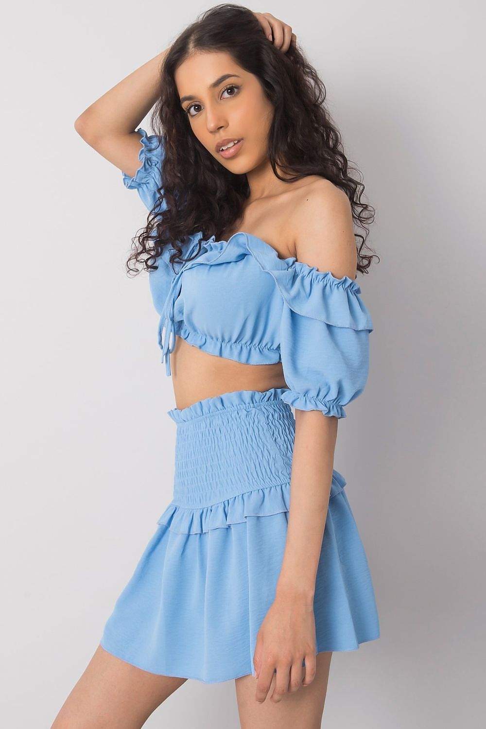 Close-up of the model in the Och Bella Women's Short Summer Skirt with Wide Elastic Waistband in blue, highlighting the stylish ruffles and elastic design, ideal for a luxurious summer look.