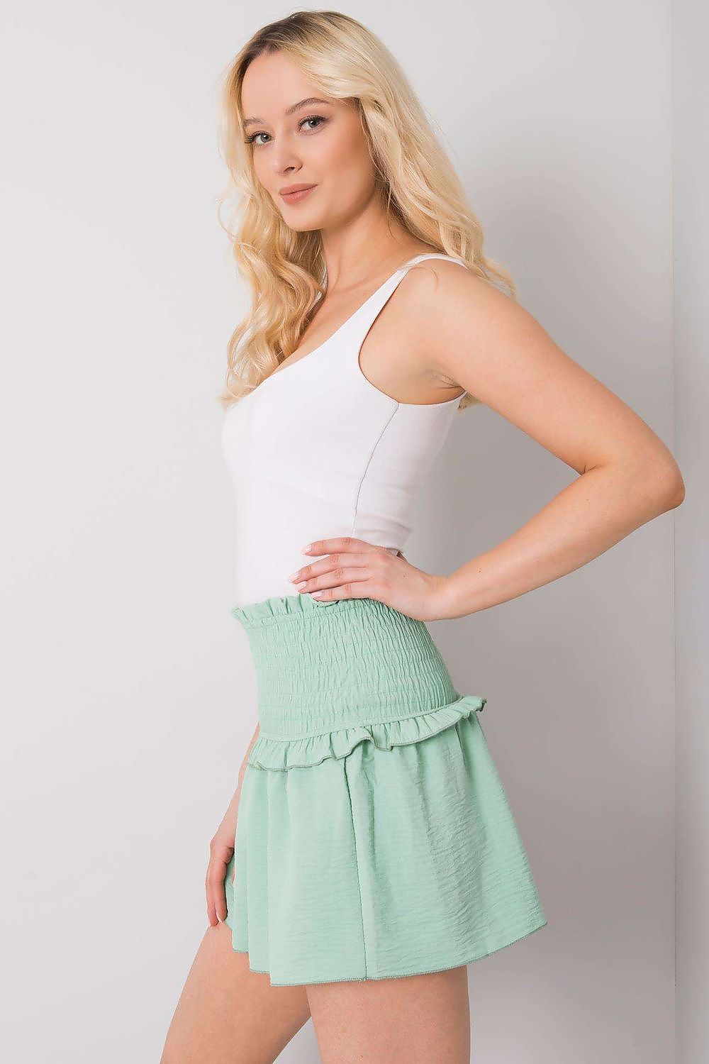 Elegant lateral view of Och Bella Women's Short Summer Skirt with Wide Elastic Waistband in mint green, showcasing its stylish design and flattering fit.