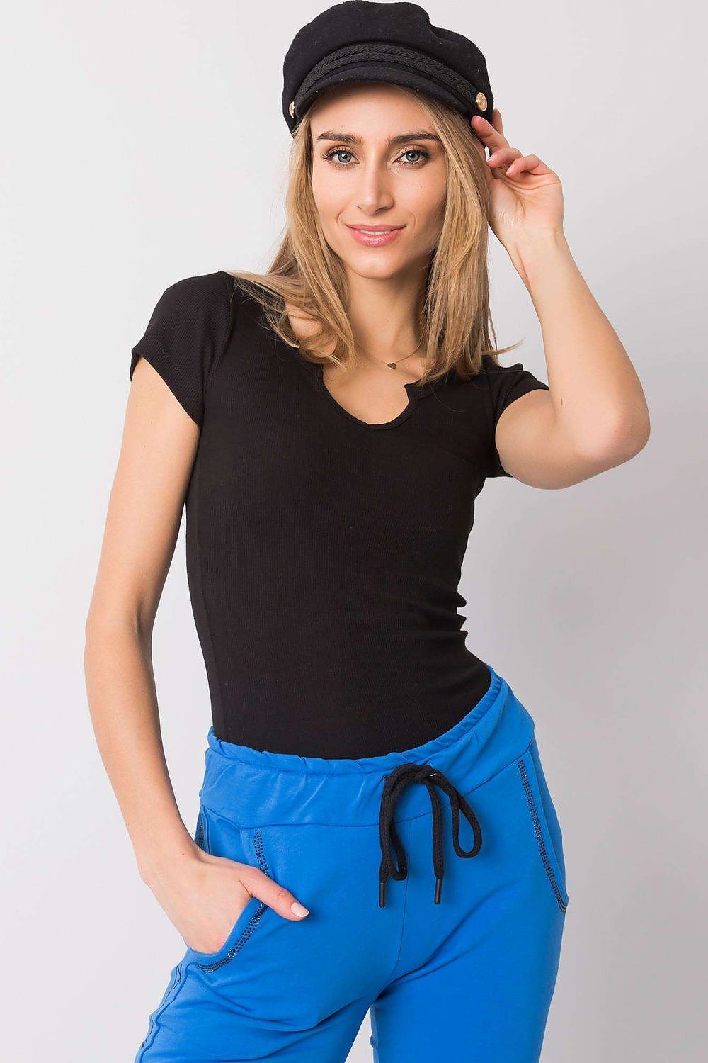 Stylish model showcasing the Och Bella Ribbed Cotton Blend T-Shirt With Cutout Neckline, elegantly paired with blue joggers for a chic and effortless look. Perfect for casual luxury.