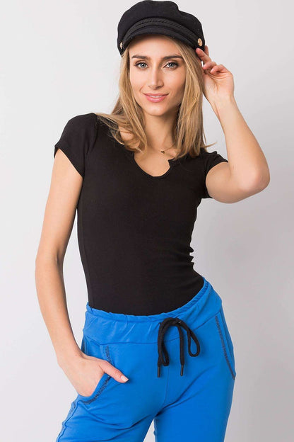 Stylish model showcasing the Och Bella Ribbed Cotton Blend T-Shirt With Cutout Neckline, elegantly paired with blue joggers for a chic and effortless look. Perfect for casual luxury.