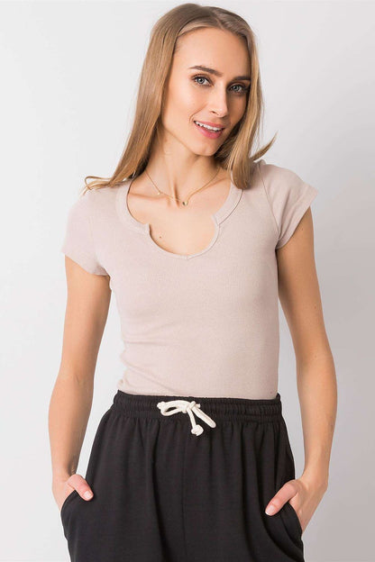 Graceful model in a neutral Och Bella ribbed cotton blend t-shirt with cutout neckline, elegantly styled with black trousers, presenting a refined casual look.