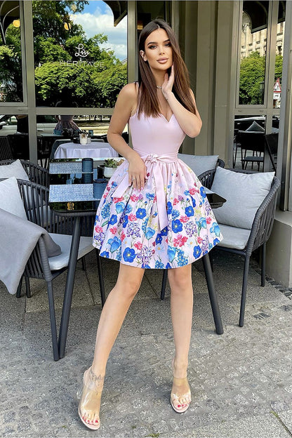 Elegant Bicotone Cocktail Dress With Lovely Pastel Dyed Flowers And Flared Layered Design showcased by a fashionable woman, highlighting the vibrant floral pattern against a sophisticated outdoor backdrop.