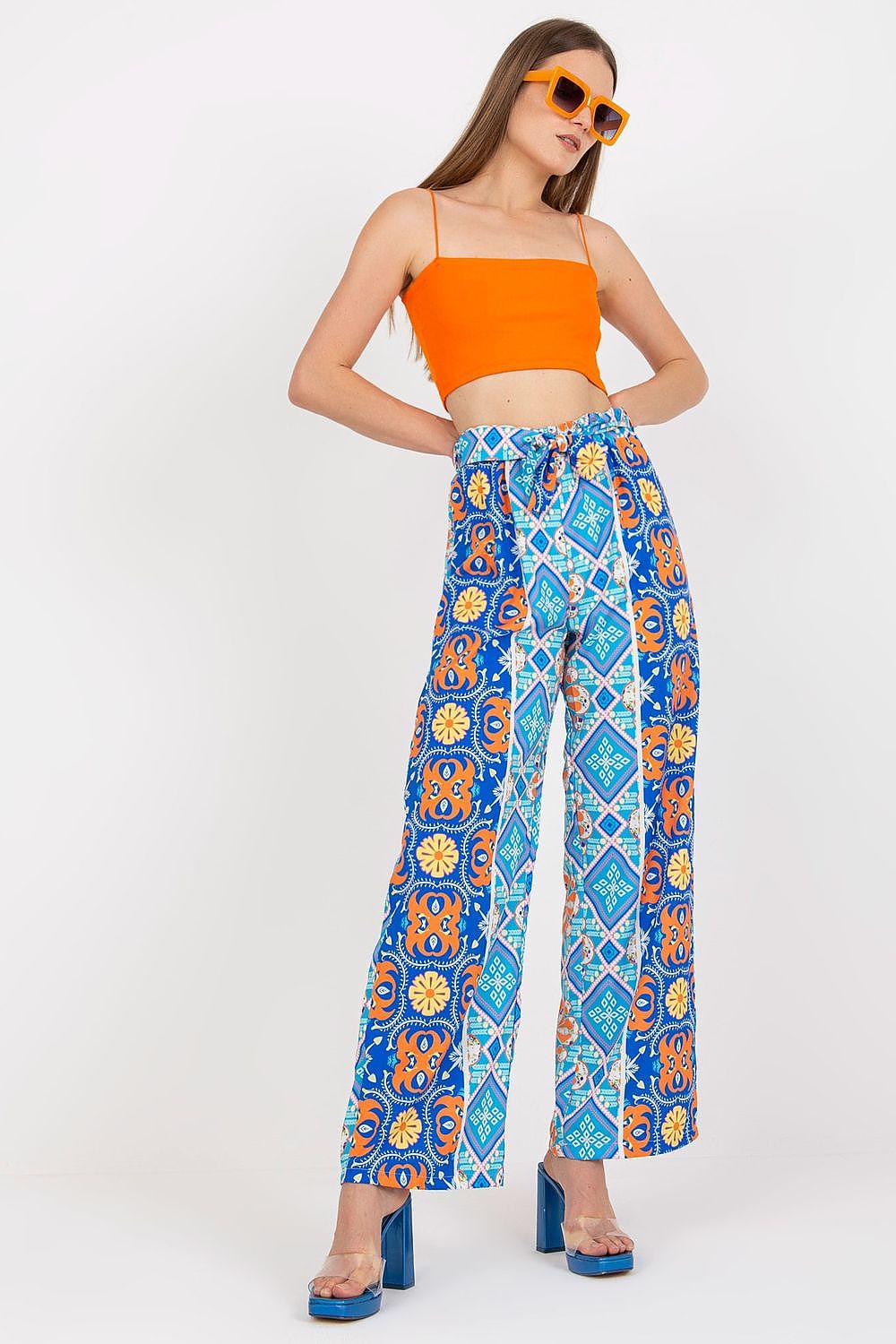 Italy Moda Women's High-Waisted Wide-Leg Trousers with Elastic Waistband - Elegant Comfort Pants showcased on a model wearing an orange crop top and stylish sunglasses, featuring a vibrant blue floral pattern.