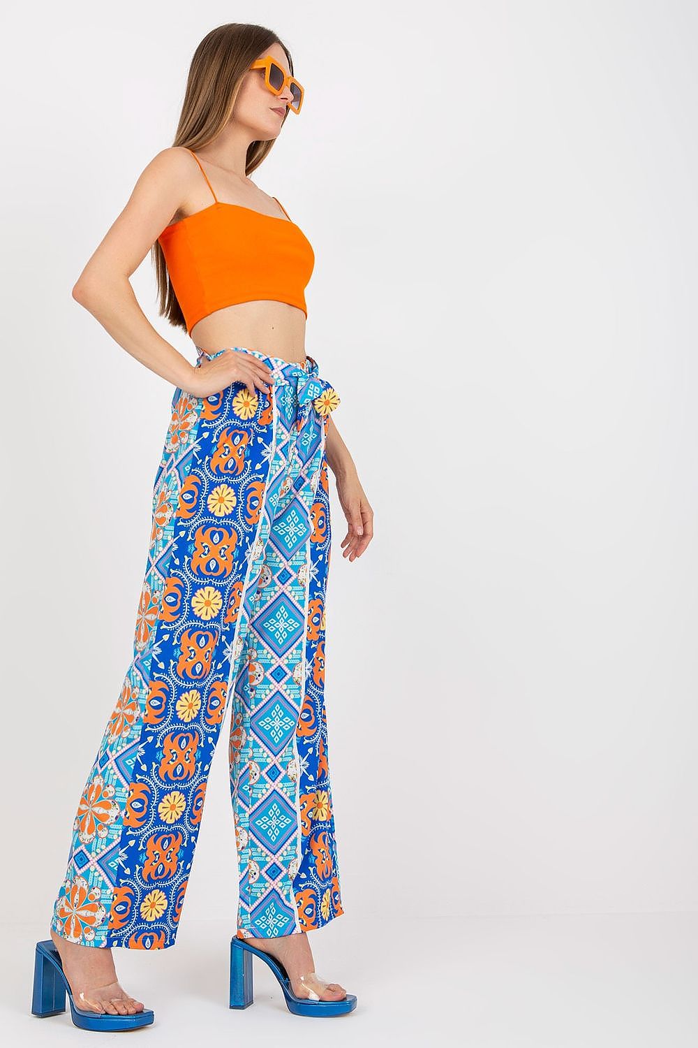 Side view of Italy Moda Women's High-Waisted Wide-Leg Trousers with Elastic Waistband - Elegant Comfort Pants, model poses in an orange crop top, exhibiting a colourful floral design.