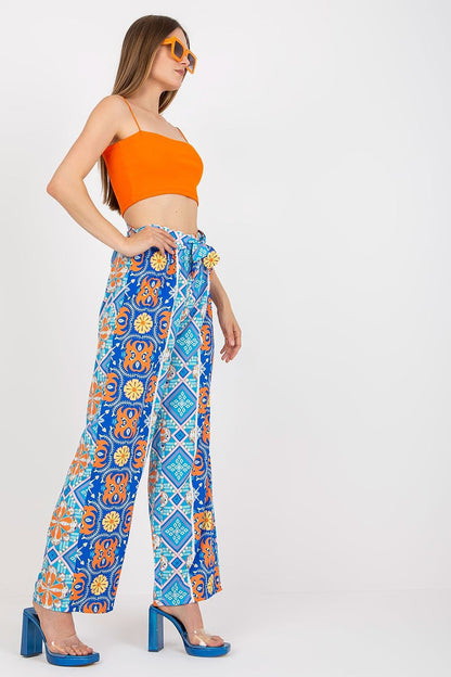 Side view of Italy Moda Women's High-Waisted Wide-Leg Trousers with Elastic Waistband - Elegant Comfort Pants, model poses in an orange crop top, exhibiting a colourful floral design.