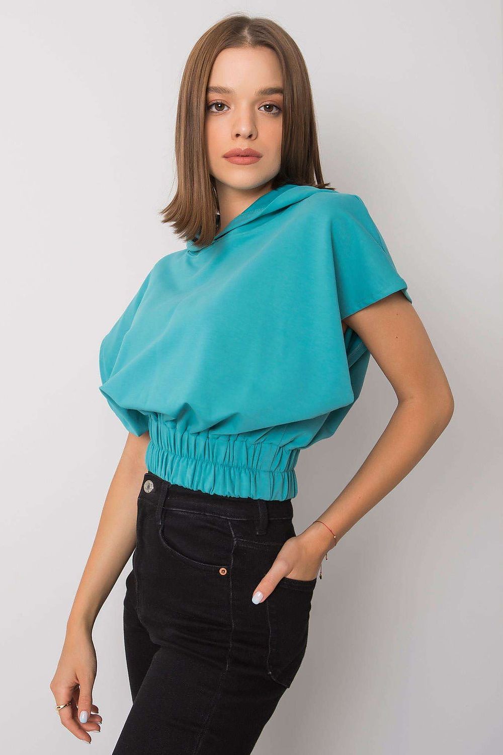 Side view of the Ladies' Loose-Fit Sweatshirt with Short Sleeves and Hood, 65% Cotton Blend, captured on a model, showcasing its luxurious fabric and effortless fashionable fit.