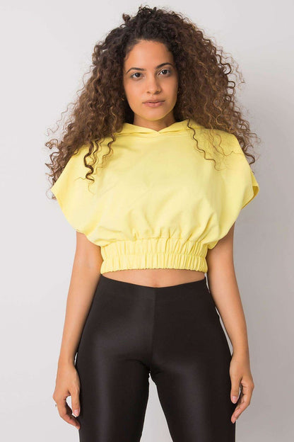 Close-up of a model wearing a Ladies' Loose-Fit Sweatshirt with Short Sleeves and Hood in yellow, highlighting its luxurious design and relaxed fit.