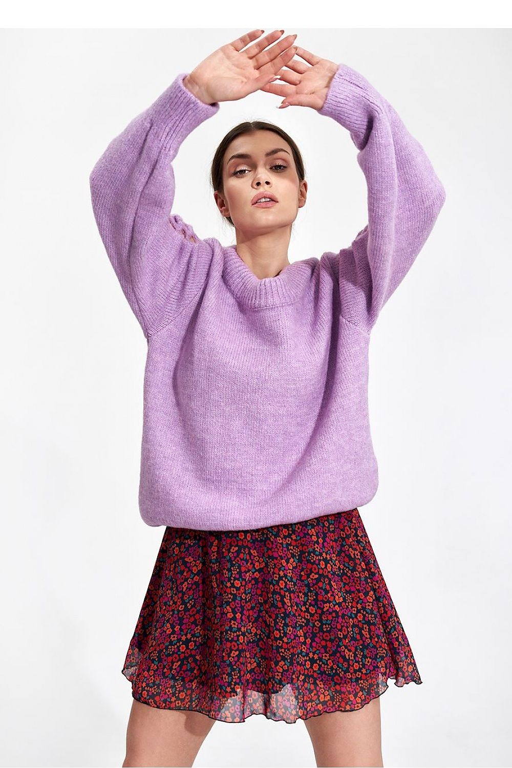 Model wearing Flared Mini Skirt by Figl, showcasing an airy floral design paired with a lavender oversized sweater for a stylish, elegant look.