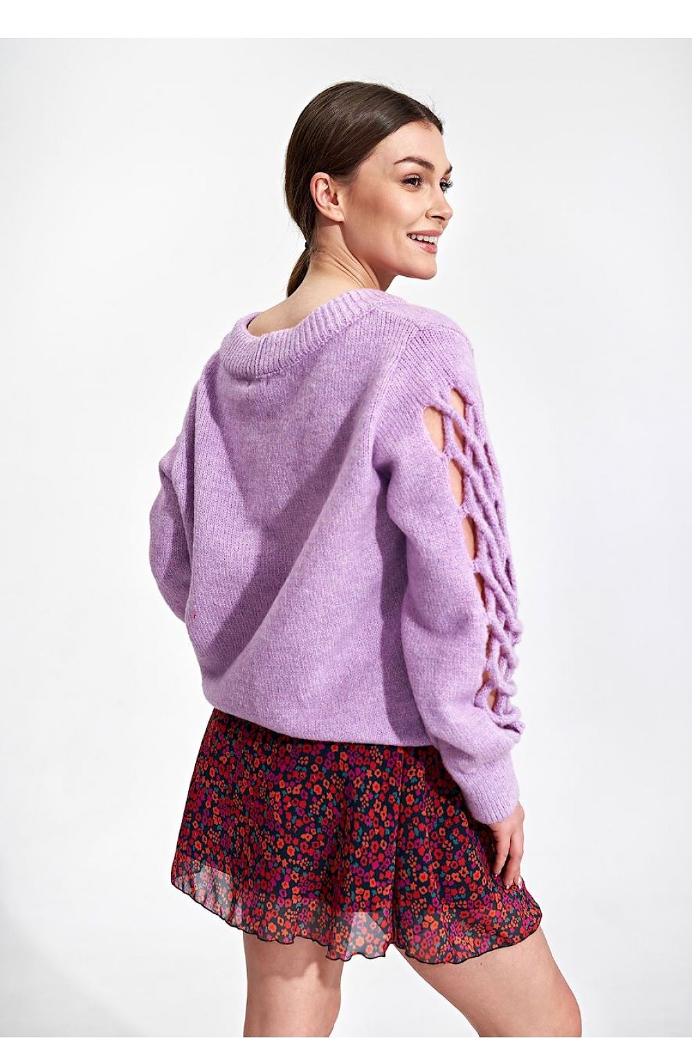 Back view of a model in the Flared Mini Skirt by Figl, accentuated by a soft lavender sweater with intricate details, ideal for a fashionable ensemble.