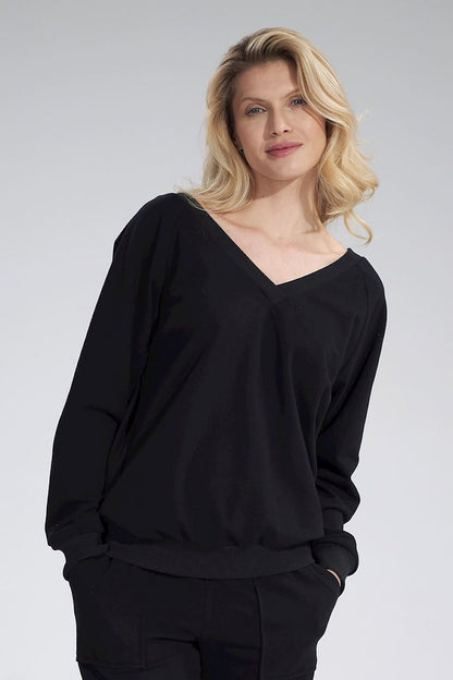 Luxury Figl V-Neck Cotton Blouse with Decorative Ribbon, featuring long sleeves and a ribbed hem, model poses elegantly in a black background.