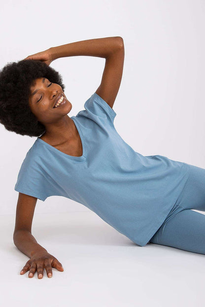 Luxury BFG Heart Neckline T-Shirt in a soft cotton blend, model with curly hair in a relaxed pose wearing a blue T-shirt.